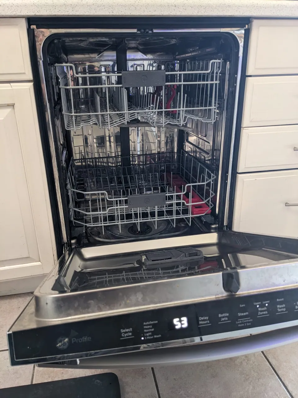 An open dishwasher with racks pulled forward during a service visit